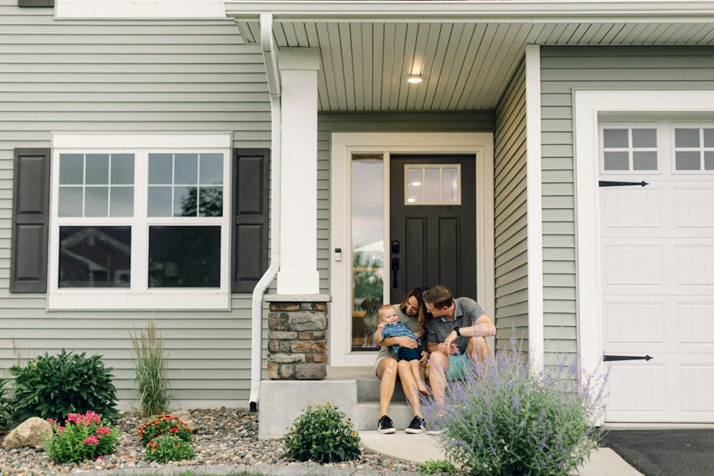 A family sitting together on the front step of their house